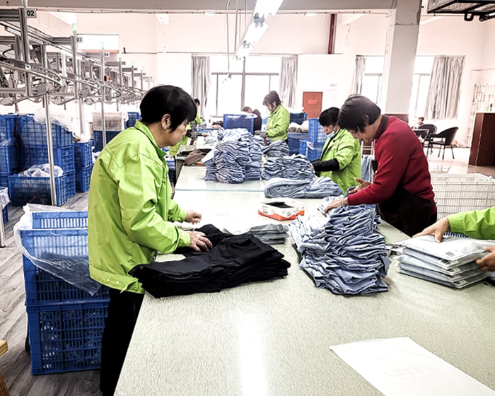 Professional quality control team performing final inspection and manual checking of seamless activewear before B2B shipping.