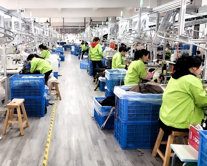 Large-scale sewing and assembly line in a seamless activewear factory, featuring specialized machinery for high-performance garment finishing.